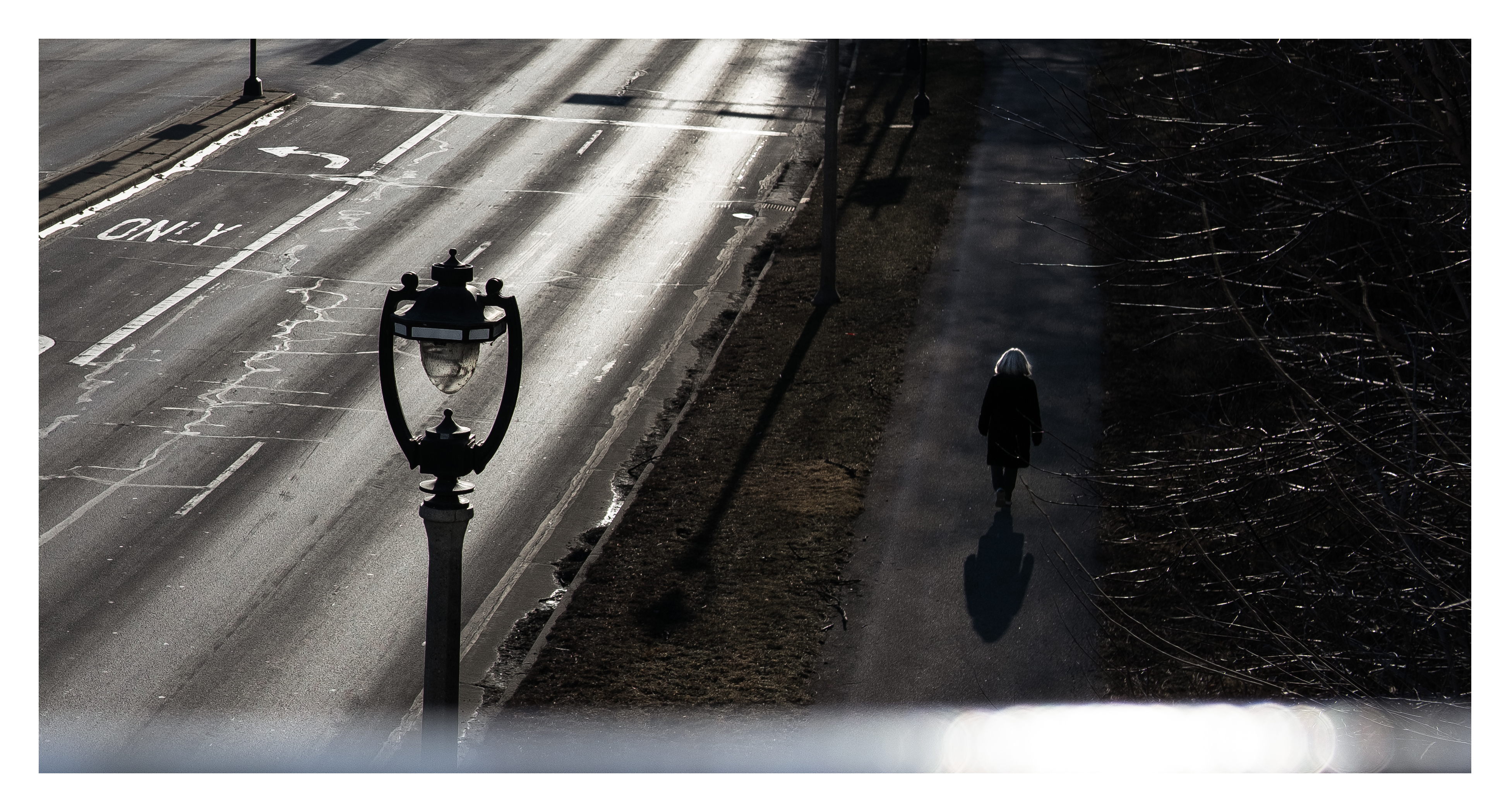 photo of a woman walking beside a bright, cold street